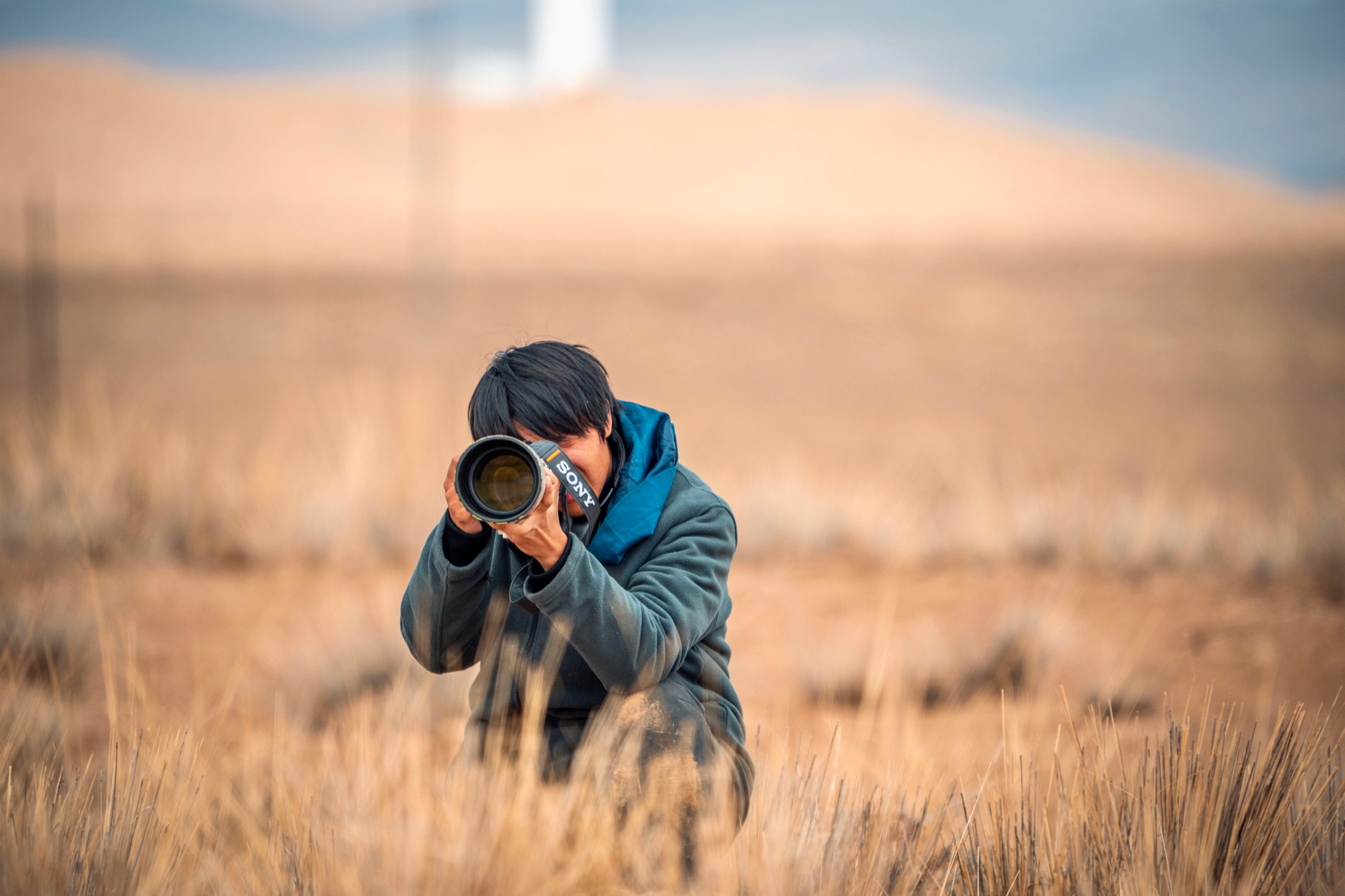 YuanZhe Cui working with a camera in grassland